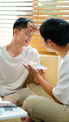 Gay couple doing each other make up, painting his boyfriends face for LGBT parade with pride...
