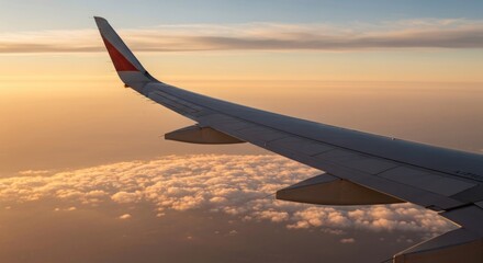 Fototapeta premium Airplane wing soars above clouds at sunset, capturing the beauty of flight.