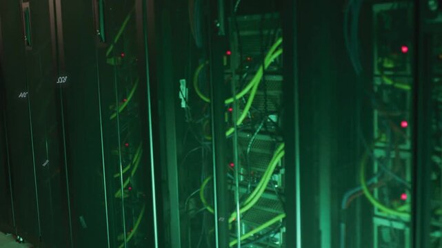 Camera tracking IT racks, revealing neon-green cables, HUD digits drifting, LEDs blinking for ops