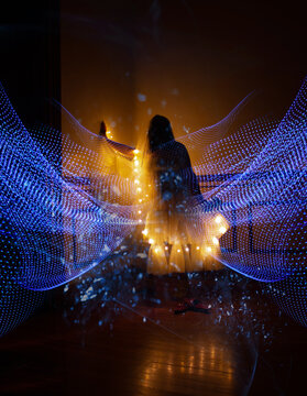 Silhouette of adult figure with flowing light waves, surreal contemplative
