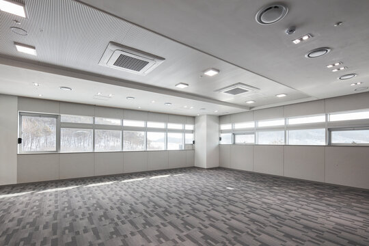 Bright vacant room with patterned carpet and continuous window band