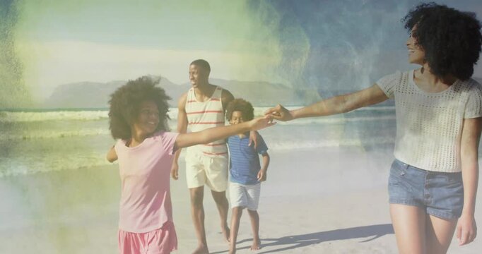Family walking sandy shore, front girl spinning and woman guiding hand, ocean waves showing travel