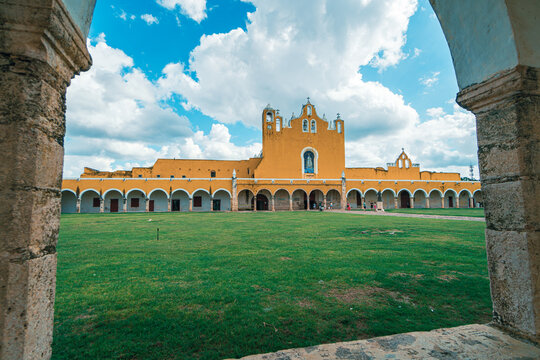 Yellow church framed by stone archway