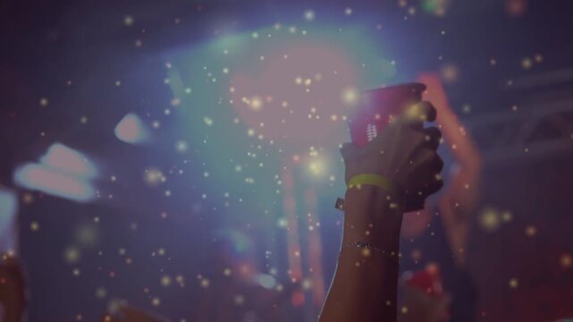 Arm raising red cup at gig, MC lifting, LEDs pulsing urging crowd, glitter drifting across crowd