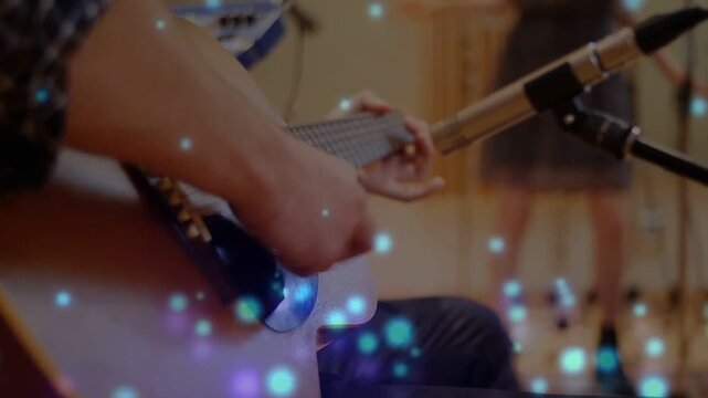 Player playing acoustic guitar recording right hand starting strum mic near hole bokeh over hands