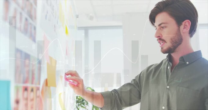 Man scanning planning wall, moving pink notes while faint chart overlays guiding business planning