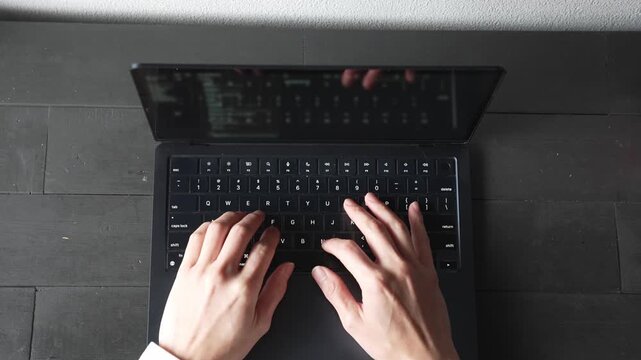ノートパソコンをタイピングする手元 俯瞰 ビジネス リモートワーク 集中 / Close-up of hands typing on laptop keyboard, top view, remote work and productivity concept