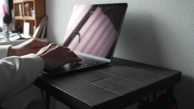 ノートパソコンをタイピングする手元 俯瞰 ビジネス リモートワーク 集中 / Close-up of hands typing on laptop keyboard, top view, remote work and productivity concept