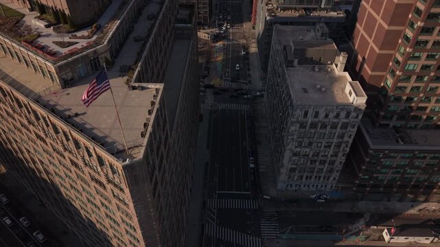 descending and tilting up shot of American flag at corner of 6th Ave. and Canal St. in NYC