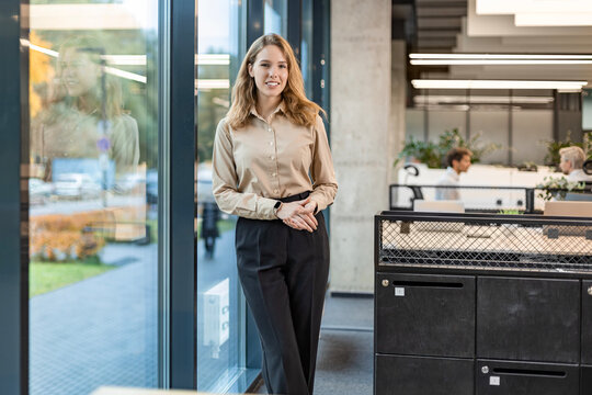 Confident stylish european woman standing at workplace, executive leader manager smiling.
