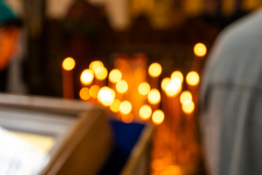 Light shines from candles inside a place of worship filled with visitors and those seeking reflection in the evening