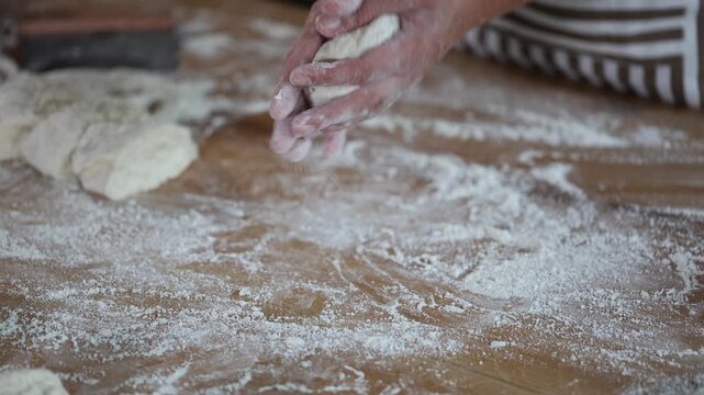  Female baker molding pieces of raw dough close-up