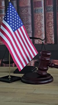 Legal concepts are displayed with American flag and scales in a courtroom setting during the day