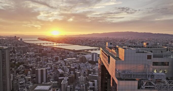 Osaka Japan Aerial v80 tracking flyover Ofukacho capturing a sprawling urban landscape and Yodo river flowing through the city under a dramatic sunset sky - Shot with Mavic 3 Pro Cine - Oct 9th 2023
