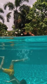 Boy swims in pool and makes splashes. Fun training for children in the sport aquatic school