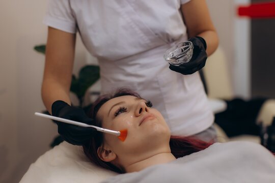 Woman receiving professional facial skincare chemical peel treatment