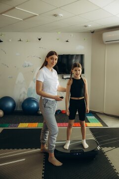 Child having physiotherapy session with vibration plate