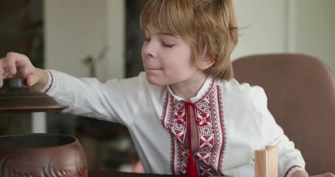 Kid Boy Waiting For Dinner. Man Serving Dishes on Table Family in Ukrainian Traditional Attire Childhood. 4K 10-bit