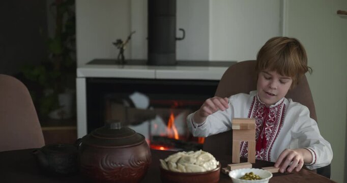 Kid Boy Waiting For Dinner. Man Serving Dishes on Table Family in Ukrainian Traditional Attire Childhood. 4K 10-bit