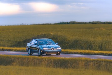 Fototapeta premium Beautifully preserved 90s style car on open highway