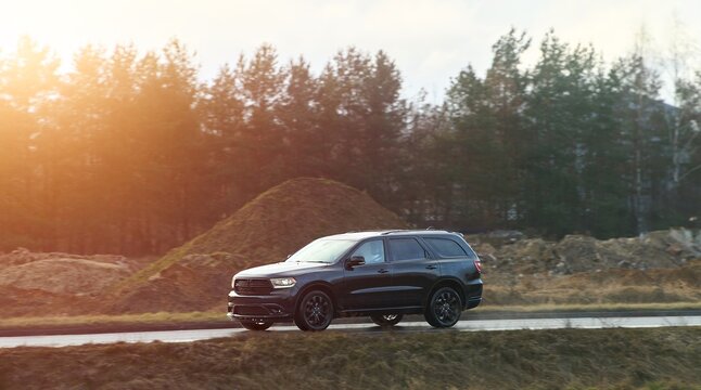 Modern crossover drives on scenic country road