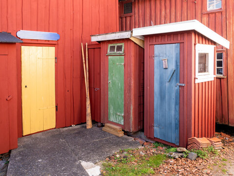 Wooden fishing gear sheds with colourful doors beside boathouse on Gullholmen island in Bohusl&auml;n, west coast Sweden