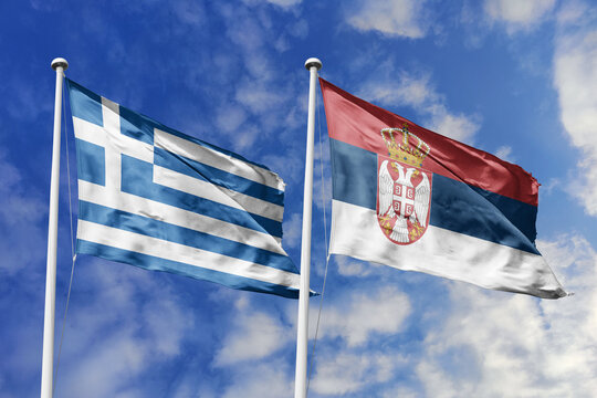 Greece and Serbia flags waving in a clear blue sky, symbolizing a powerful diplomacy, expanding global trade, a strategic partnership, and a shared vision of unity for a sustainable future.