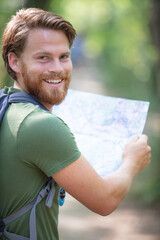 young handsome hiker using map in the nature