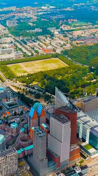 Vertical video. The Hague, Netherlands. Business center of The Hague. Large train station Den Haag Centraal. Cloudy weather. Summer day. Drone footage, Point of interest. Rich colors