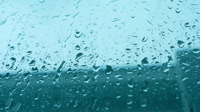 Raindrops cover a window during heavy rainfall, highlighting storms, climate change impacts, and increasing weather unpredictability linked to global warming and shifting environmental conditions.