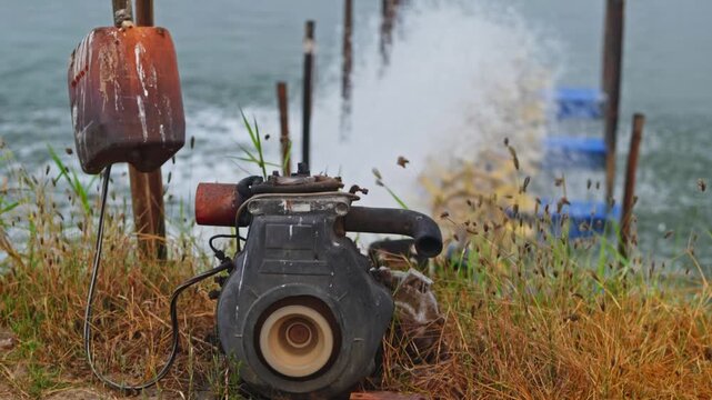 Diesel can with Engine and running paddle wheel aerator in aquaculture pond. day time, zoom out shot, hand held shot, 4k.