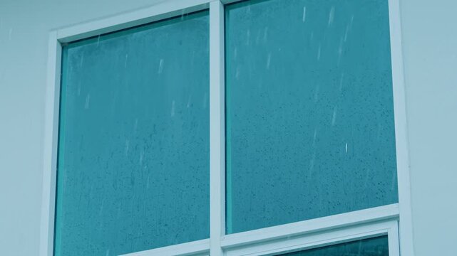 Raindrops covering a window surface during intense rainfall, illustrating changing climate conditions, increased storm frequency, and the visible effects of global warming on everyday surroundings.
