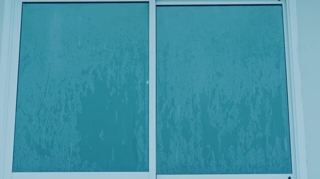 Heavy rain streaks across a glass window, highlighting extreme weather intensity, climate change impacts, and rising precipitation levels linked to global warming and shifting environmental patterns.
