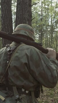 Reenactor Dressed As German Infantry Soldier Going By Forest In Slo-mo Slow Motion Slow-mo. Soldier With Carabines Mauser 98k Combing Forest Autumn Season. Reenactment Tactic Game. Wermacht Uniform