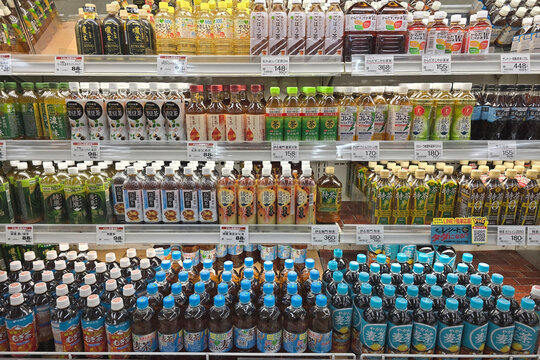 Beppu, Japan - Jan 07, 2026: Rows of various bottled beverages including barley tea, green tea, and health-focused drinks displayed on refrigerated shelves in a supermarket in Beppu.
