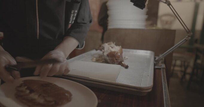 chef skillfully Peking duck slices succulent meat for an eager crowd, showcasing expertise.