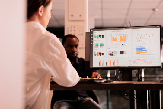 Employee analyzing company financial report dashboard on computer screen, woman working on business research statistics in coworking space, back view. Corporate worker checking analytics