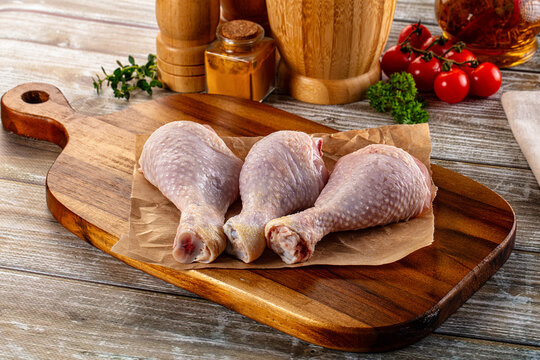 Fresh raw chicken drumstick over board