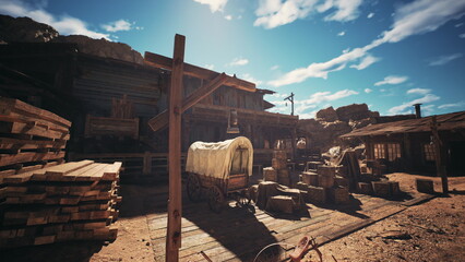 A dusty old western building stands in a deserted area surrounded by wooden crates and a covered wagon under a bright blue sky with fluffy clouds. © icetray