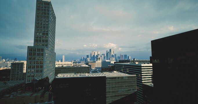Buildings and skyline view, Urban rooftops lead to towering skyline, Rooftop assemblies and vents guide eye toward clustered city skyscrapers