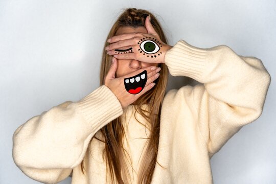 Playful creative portrait with hand face paint and copy space