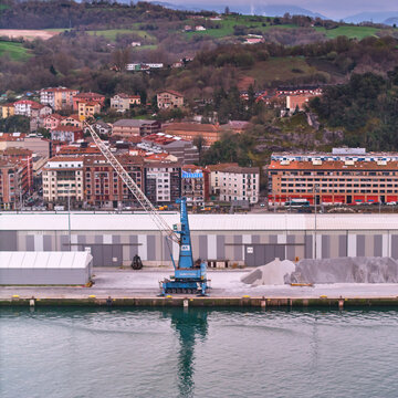 Pasai Donibane, Spain - 10 March 2026: Aerial view of the harbor's edge, where the blue crane stands tall against the backdrop of the town's terracotta roofs.