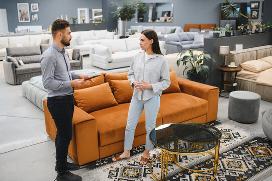 Female client consulting male sales consultant in furniture shop