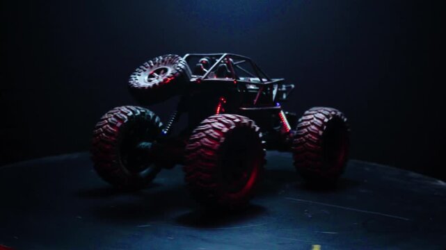 off-road toy cars turn with big tires art creative in water splashes 360 degree rotation on dark background with red backlight