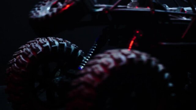 off-road toy cars turn with big tires art creative in water splashes 360 degree rotation on dark background with red backlight