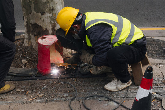 A man in uniform repairs a road. City service