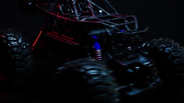 off-road toy cars turn with big tires art creative in water splashes 360 degree rotation on dark background with red backlight