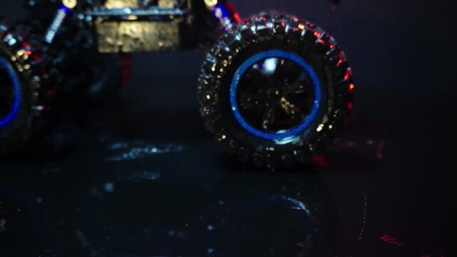 off-road toy cars turn with big tires art creative in water splashes 360 degree rotation on dark background with red backlight