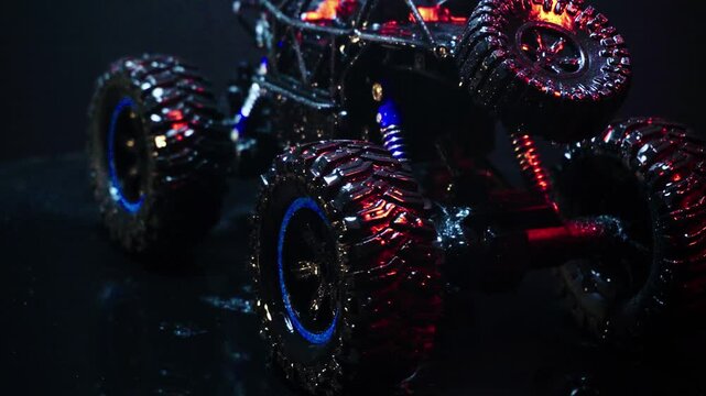off-road toy cars turn with big tires art creative in water splashes 360 degree rotation on dark background with red backlight