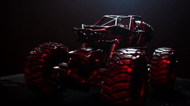off-road toy cars turn with big tires art creative in water splashes 360 degree rotation on dark background with red backlight